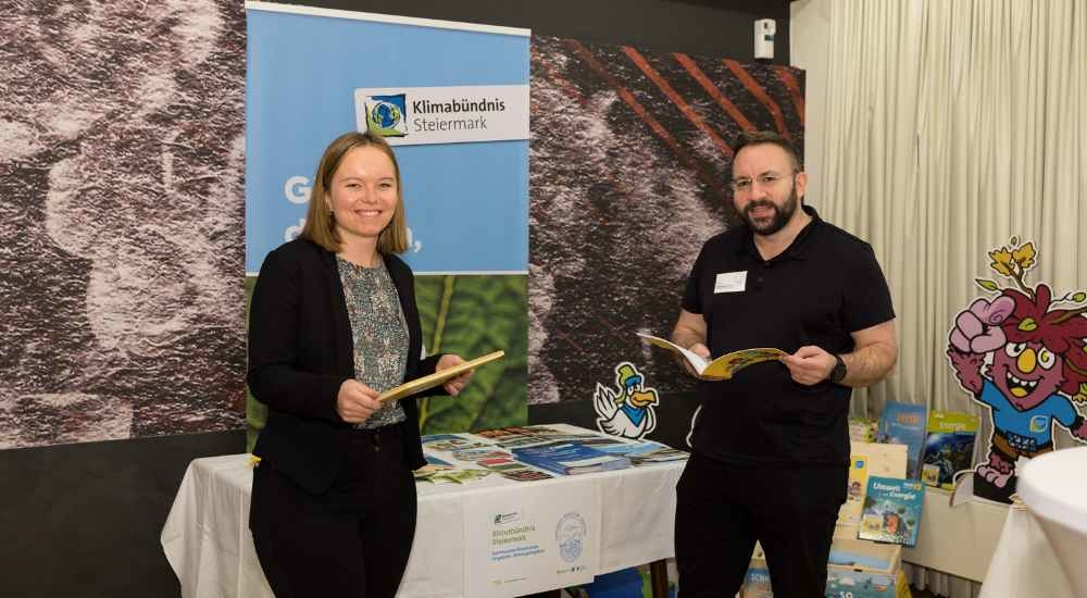 Raffaela Miglbauer und Klaus Minati vom Klimabündnis Steiermark vor dem Infostand bei der Gemeindekonferenz in Frohnleiten