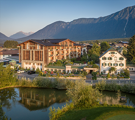 Hotel Alpenresort vor See mit Bergen im Hintergrund in Schwarz Tirol