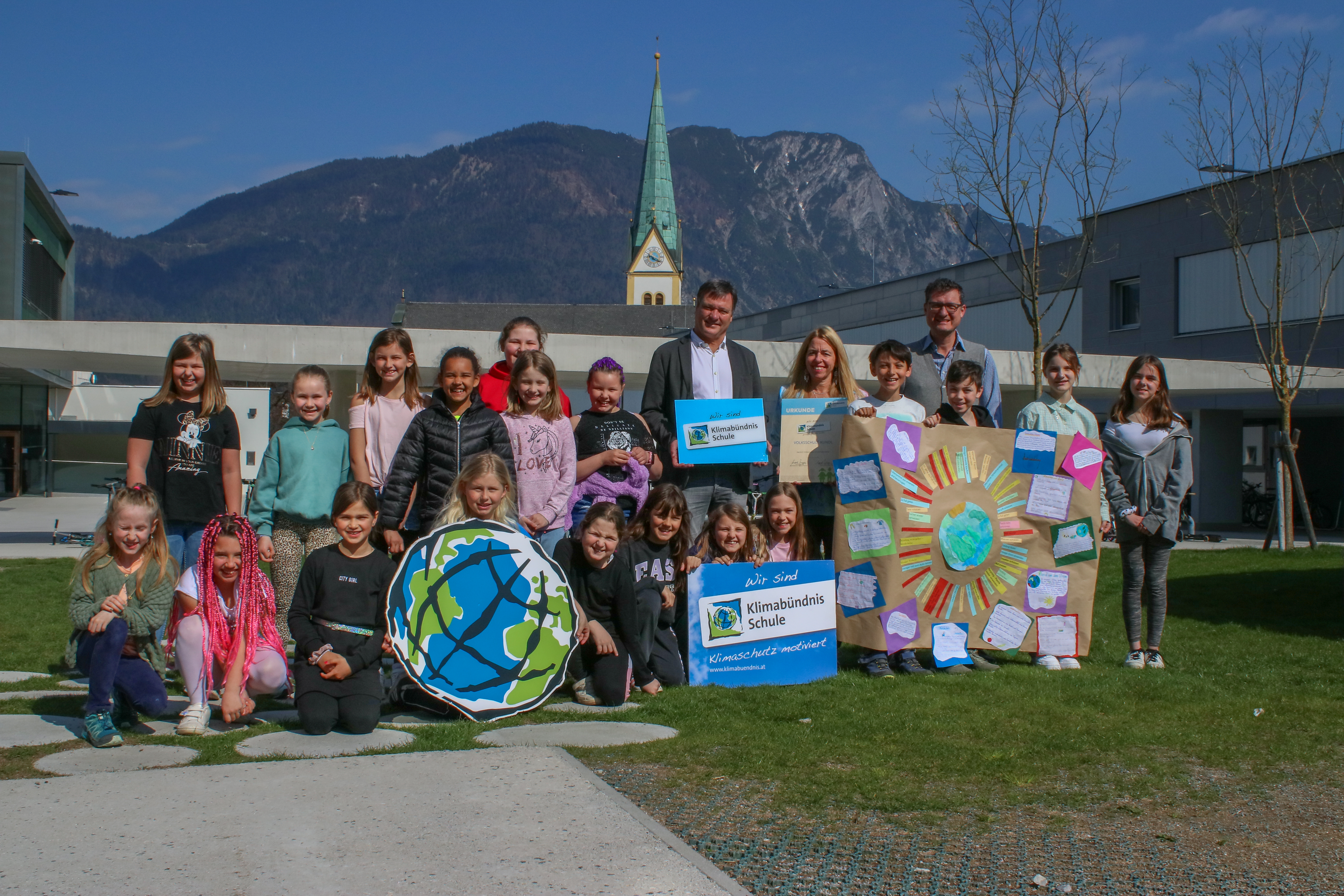 Kinder der VS Kundl bei feierlichen Klimabündnisbeitritt mit bunten Schildern und Plakaten