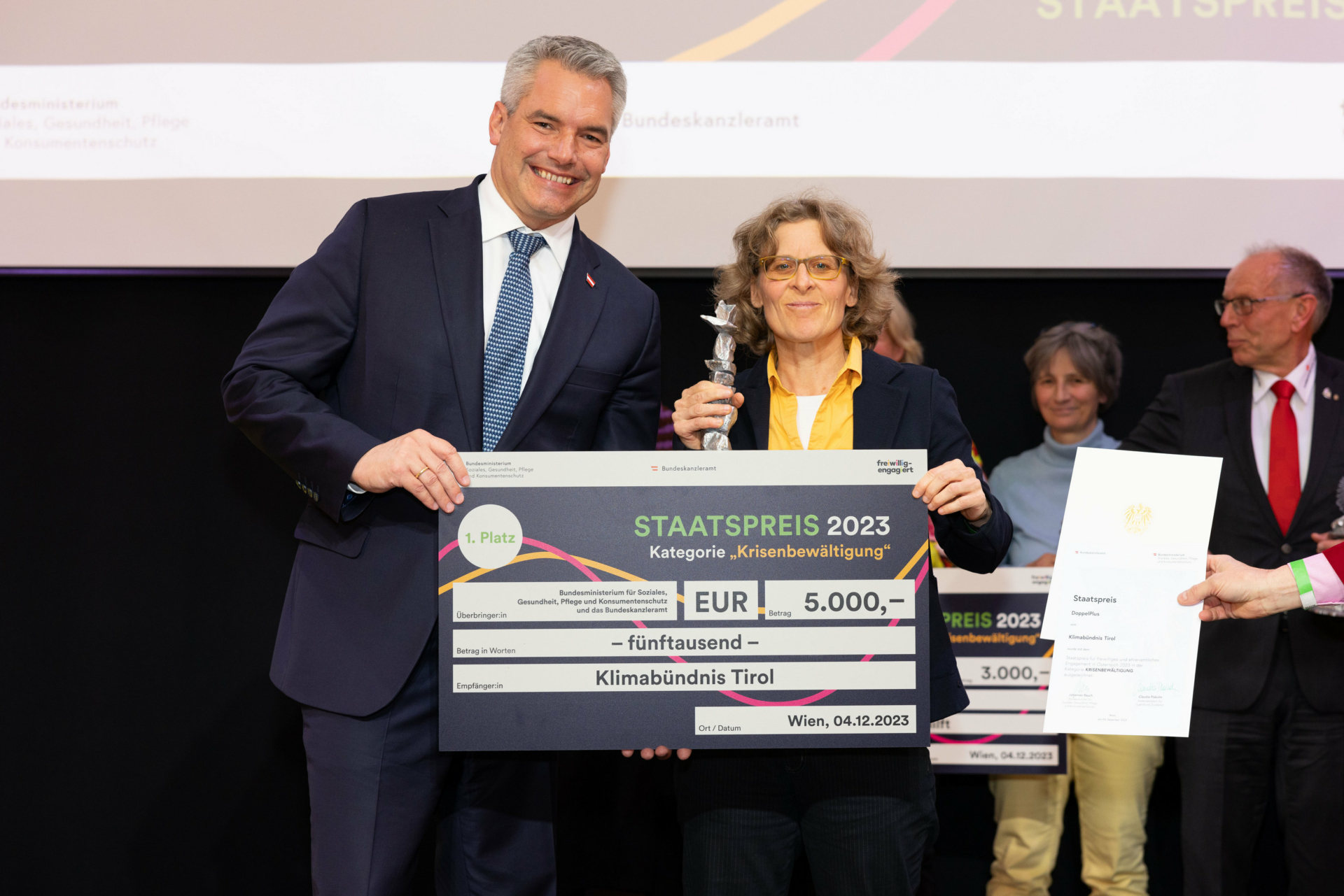 Irene Milewski von Klimabündnis Tirol nimmt den 1. Staatspreis für freiwilliges und ehrenamtliches Engagement von Bundeskanzler Karl Nehammer entgegen.