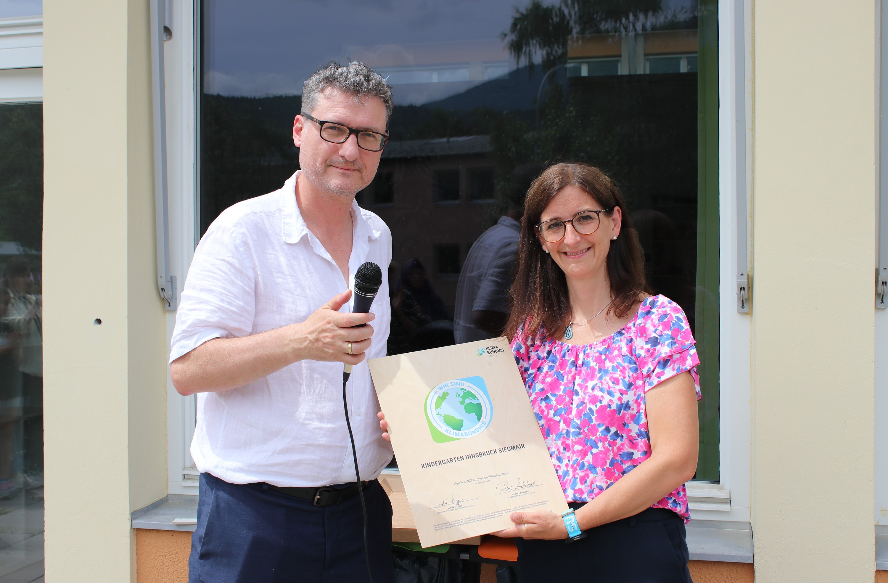Geschäftsführer von Klimabündnis Tirol Andrä Stigger überreicht Kindergartenleiterin Alice Aschauer die Urkunde