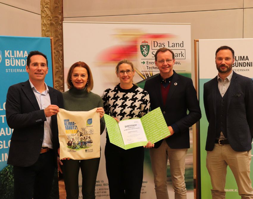 fünf Erwachsene mit Zertifikat und Klimaschutz Beitrag Beutel vor Klimabündnis und Das Land Steiermark Banner