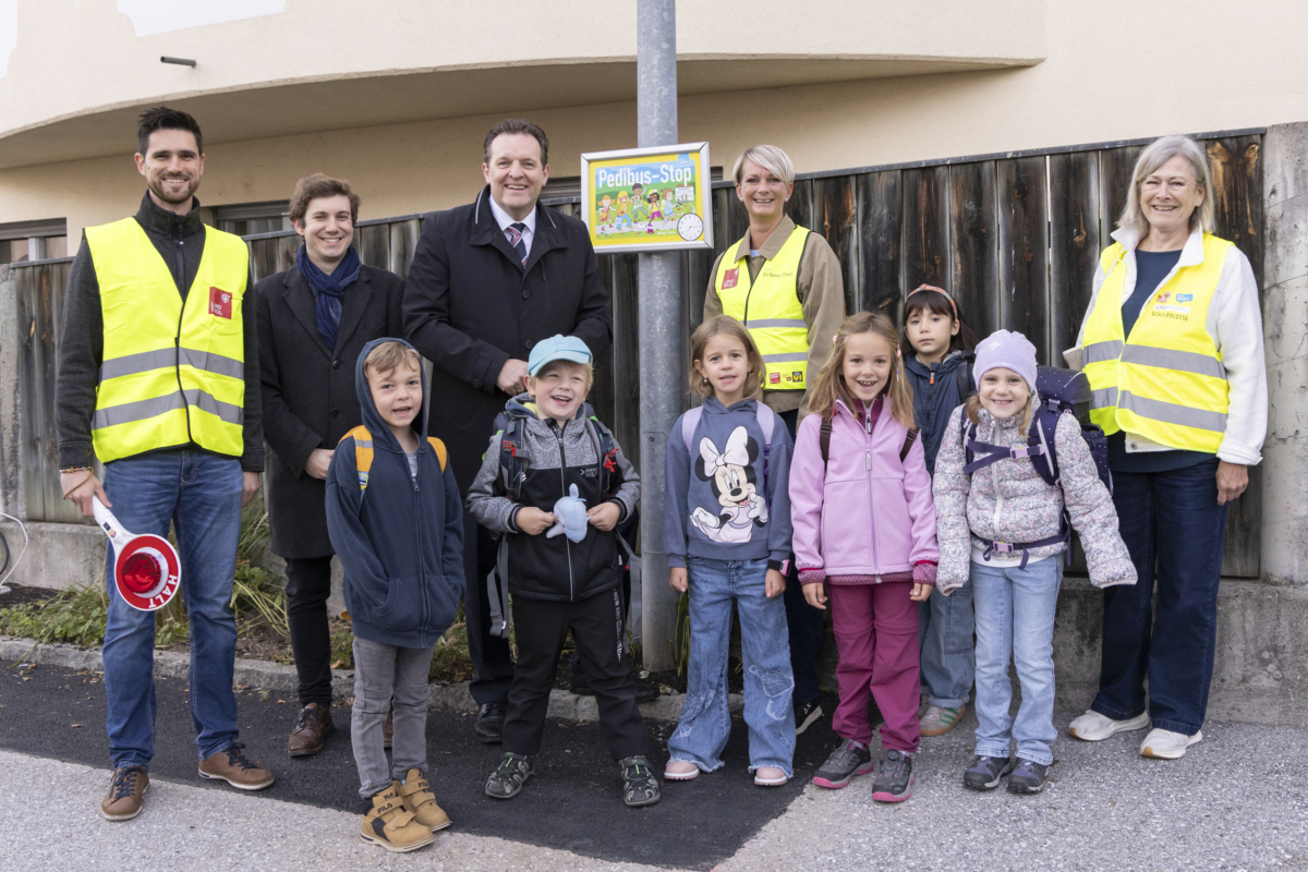 Pedibus-Stop-Initiative mit Kindern und Erwachsenen in gelben Warnwesten in Österreich